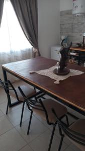 a dining room table with two chairs around it at Cabaña de campo La Tabanerina in Salto de las Rosas