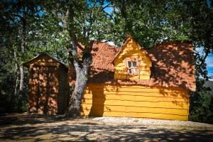 ein gelbes Haus mit einem Baum davor in der Unterkunft Camping le Colorado in Rustrel