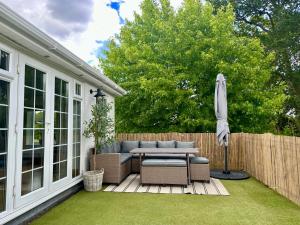 eine Terrasse mit einem Tisch und einem Sonnenschirm in der Unterkunft The Castleman in Ferndown