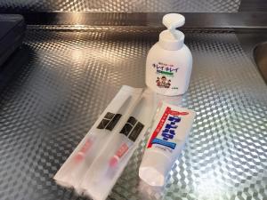 a metal shelf with two toothbrushes and a bottle of toothpaste at avanti house大橋A3 in Shiobaru
