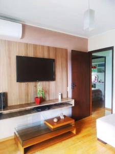 a living room with a flat screen tv on a wall at SHOW RURAL 2024- casa com ar e piscina in Cascavel