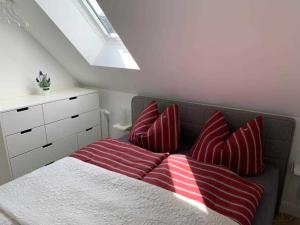 een slaapkamer met een bed met rode en witte kussens bij Haus Lindenstraße 3 
