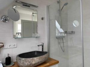 een badkamer met een wastafel en een glazen douche bij Haus Lindenstraße 3 