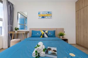ein Schlafzimmer mit einem blauen Bett und einer Zeitschrift darauf in der Unterkunft THE SÓNG VŨNG TÀU - QUỲNH's Homestay in Vũng Tàu