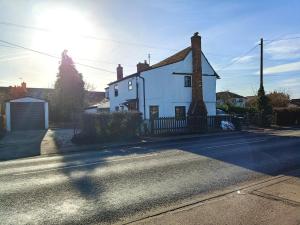 a white house on the side of a street at Stansted Airport Cottage in Bishops Stortford