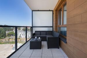 a balcony with a couch and a table at Bel Mare Modern Apartment with Balcony by Renters in Międzyzdroje