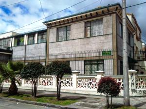 a building with a fence and trees in front of it at Hotel Andino Real in Bogotá