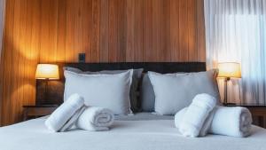 una habitación de hotel con toallas en una cama con dos lámparas en RentUp - Experimenta la belleza de San Martin de los Andes, en San Martín de los Andes
