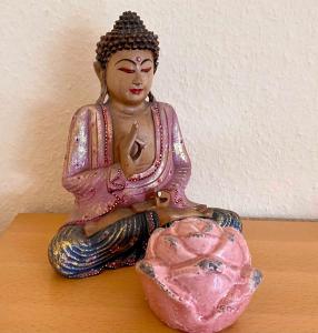een standbeeld van een Boeddha zittend op een tafel bij Sonnenkoje in Apensen
