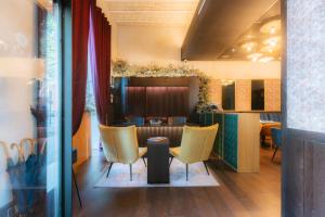 restauracja z żółtymi krzesłami i stołem w pokoju w obiekcie Cavalta Boutique Hotel GL w Sewilli
