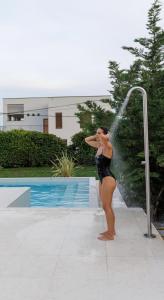 Una donna in costume da bagno che gioca con una fontana di Villa Botanica - New family house near the sea a Kaštela (Castelli)