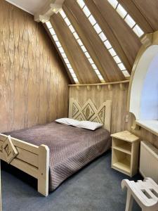 a bedroom with a bed in a room with a skylight at Hotel Veles in Zolotonosha