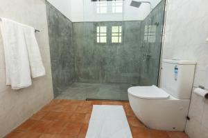 a bathroom with a shower and a toilet at Indra Manel Family Holiday Resort Kandy in Kandy +40 photos