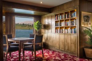 a dining room with a table and chairs and a book shelf at Steigenberger Royale Nile Cruise - Every Thursday from Luxor for 07 & 04 Nights - Every Monday From Aswan for 03 Nights in Aswan