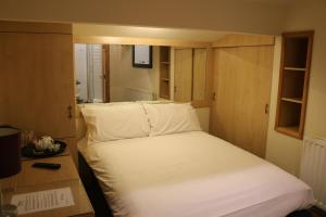 a small bedroom with a white bed and a desk at Lower Turks Head in Manchester