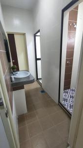 un bagno con lavandino, WC e specchio di Homestay Gerik Le rizq Homestay~ Heart of Gerik ~ Cozy a Gerik