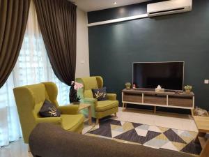 a living room with two chairs and a flat screen tv at Homestay Gerik Le rizq Homestay~ Heart of Gerik ~ Cozy in Gerik