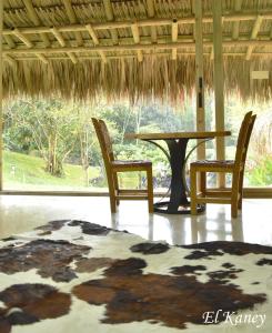 einen Tisch und Stühle in einem Zimmer mit Blick auf ein Feld in der Unterkunft HERMOSA FINCA A 20 KM DE MEDELLIN LLENA DE NATURALEZA in Girardota