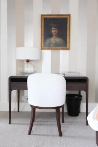 białe krzesło siedzące obok biurka ze zdjęciem w obiekcie La Maison Jules w Tours