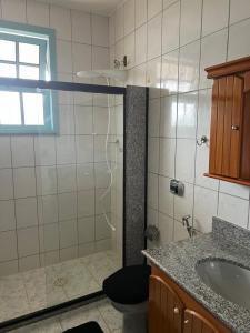 a bathroom with a shower with a toilet and a sink at Castelinho de Ibicuí in Mangaratiba
