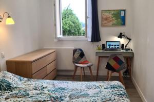 a bedroom with a bed and a desk with a laptop at Castellane : T2 spacieux - Vue Port - WIFI in Port-Vendres