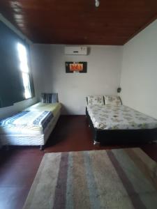 a room with two beds and a rug at Pousada do Guerreiro in Cachoeira