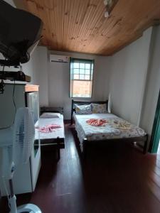 Habitación con 2 camas y ventilador. en Pousada do Guerreiro en Cachoeira