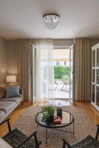 un soggiorno con divano e tavolo in vetro di Villa Botanica - New family house near the sea a Kaštela (Castelli)