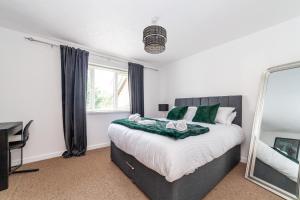 a bedroom with a large bed and a mirror at Mead Court Estate Apartment in Egham By Rent Firmly Short Lets Serviced Accommodation With Free On-Site Parking in Egham