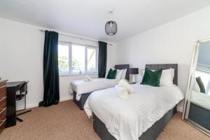 a bedroom with two beds and a desk and a mirror at Mead Court Estate Apartment in Egham By Rent Firmly Short Lets Serviced Accommodation With Free On-Site Parking in Egham