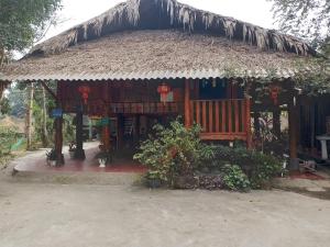 a hut with a bench and a thatch roof at Vu Linh Homestay in Vũ Linh