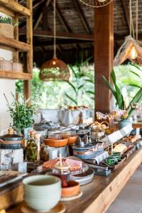 a buffet of food on a wooden table at Vila Dos Orixás Boutique Hotel in Morro de São Paulo