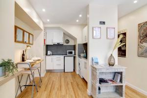 a kitchen with white cabinets and a table at Bougainvillea House in Faro