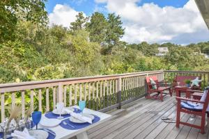 une terrasse en bois avec une table et des chaises. dans l'établissement Waterfront easy access to town center, à Wellfleet