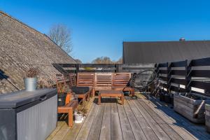 una terraza con banco, mesa y raqueta de tenis en Bjerred B&B, en Bjärred