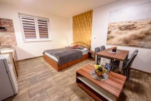 a small room with a bed and a table and a dining room at Apartmány DoLosin in Velké Losiny