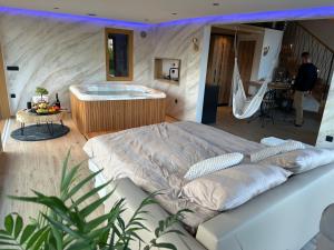 a bedroom with a large bed and a tub at Luxury Resort Potatoland in Šenčur
