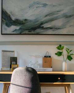 un escritorio con una silla y un cuadro en la pared en Launchpoint Lodge, en Lincoln