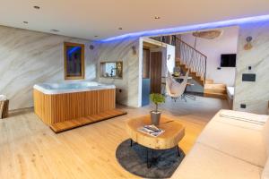Luxury Resort Potatoland في Šenčur: غرفة معيشة مع حوض استحمام وأريكة