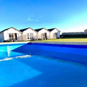 a blue swimming pool in front of some houses at Wczasowa Gąska in Gąski