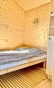 a small room with a bed in a wooden wall at Wczasowa Gąska in Gąski