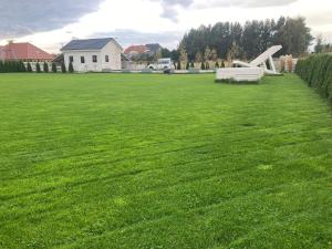 a large grassy field with a bench in a yard at Wczasowa Gąska in Gąski