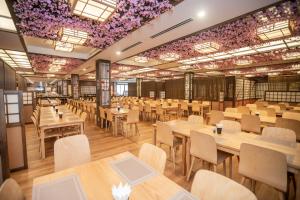 un restaurante con mesas, sillas y flores púrpuras en el techo en Vé tắm Yoko Onsen Quang Hanh - khung giờ sáng, en Cẩm Phả