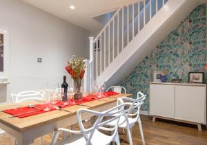 uma sala de jantar com uma mesa de madeira e cadeiras brancas em Fern Cottage - Whitstable em Whitstable