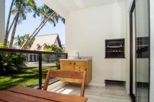cocina con escritorio y balcón con palmeras en Vila Florida, Apartamento Quadra Mar nos Ingleses Norte TC4747, en Florianópolis
