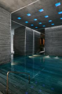 - une piscine avec des lumières bleues dans un bâtiment dans l'établissement 7132 Hotel, à Vals