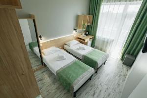 a hotel room with two beds and a mirror at Hotel Vesna in Truskavets