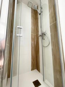 um chuveiro com uma porta de vidro na casa de banho em RELAI DU CHATEAU APPARTHOTEL em La Tourlandry