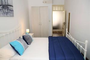a bedroom with a large white bed with blue pillows at PDL Central Apartments - Three in Ponta Delgada