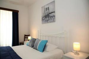 a bedroom with a white bed with blue pillows at PDL Central Apartments - Three in Ponta Delgada
